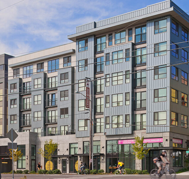 front facade of mixed use multifamily building with vertical metal siding